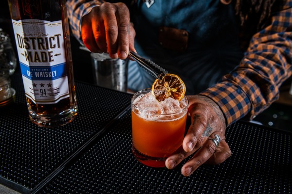 Bar tender making a cocktail with District Made spirits 