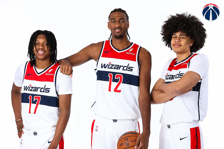 Three players from the Washington Wizards pose together in their team jerseys for a promotional image.