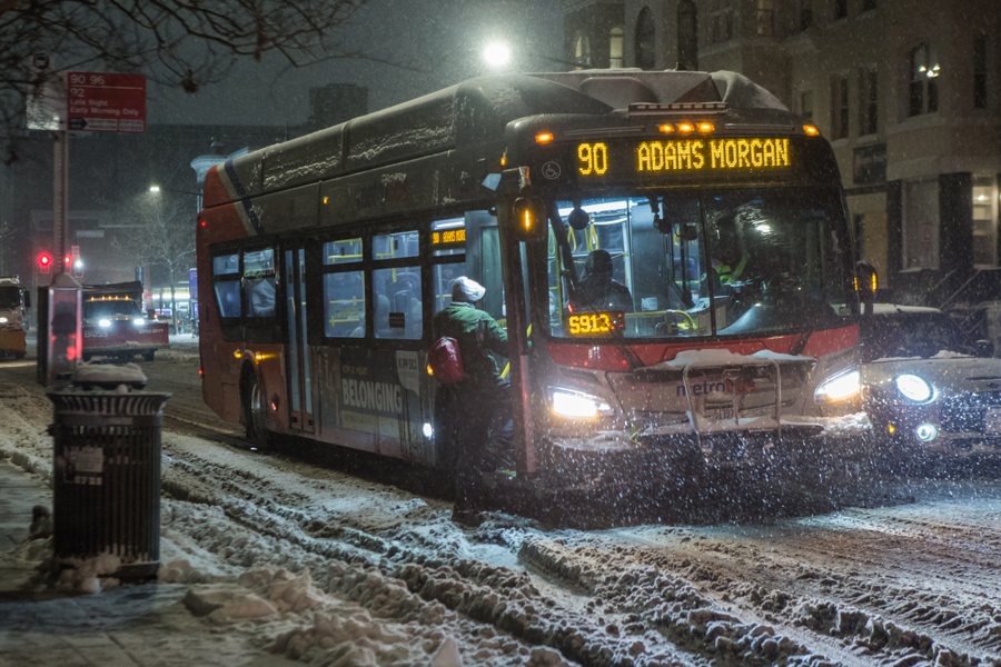 Bus pulling up to Adams Morgan Bus stop in the snow 