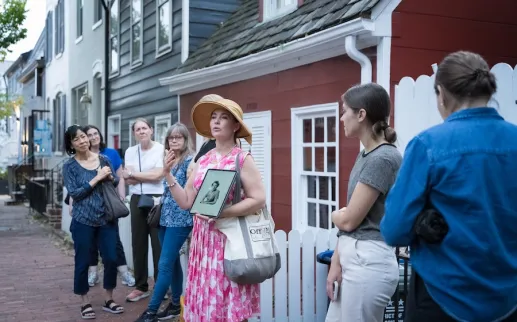 A tour guide speaks to a group during a historic walking tour in Georgetown, Washington, DC.
