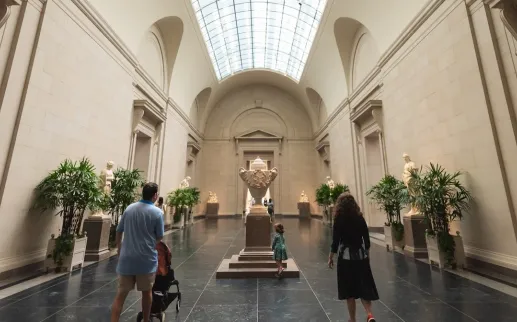 People walk down a grand hallway at the National Gallery of Art.
