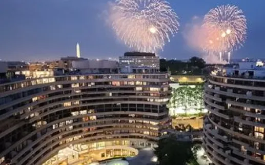 View of the Watergate Hotel with fireworks and the Washington Monument in the background
