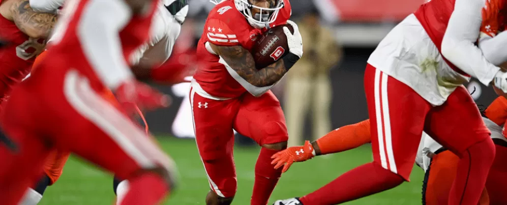 Football player running through people with the football